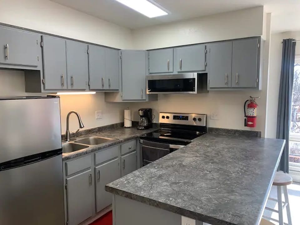 Fully stocked kitchen with drink ware, dishes, cooking utensils and pots/pans. 