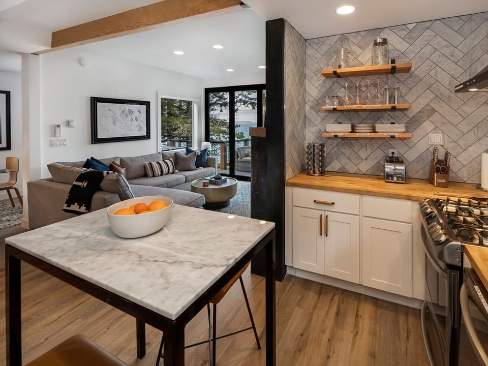 An island with seating and stainless-steel appliances make this kitchen a cook's dream. The "little extras" will help make your use of the kitchen enjoyable, including a gas range and other perks like a blender and a waffle maker.