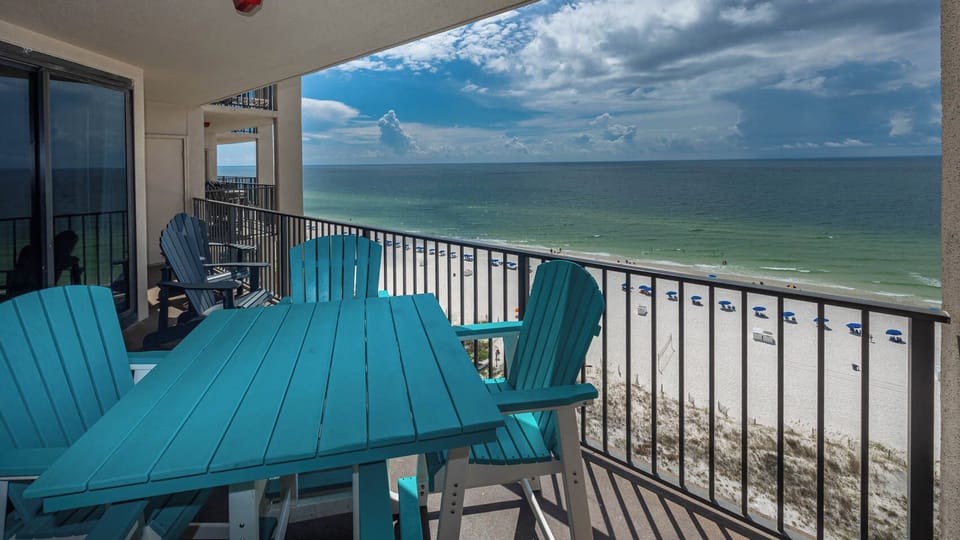 Relax on the balcony with vibrant chairs and stunning views of the beach and tranquil gulf waters
