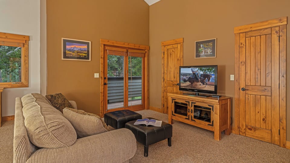 Bedroom 1, Upper Level - Primary king suite with TV, balcony, and queen sleeper sofa