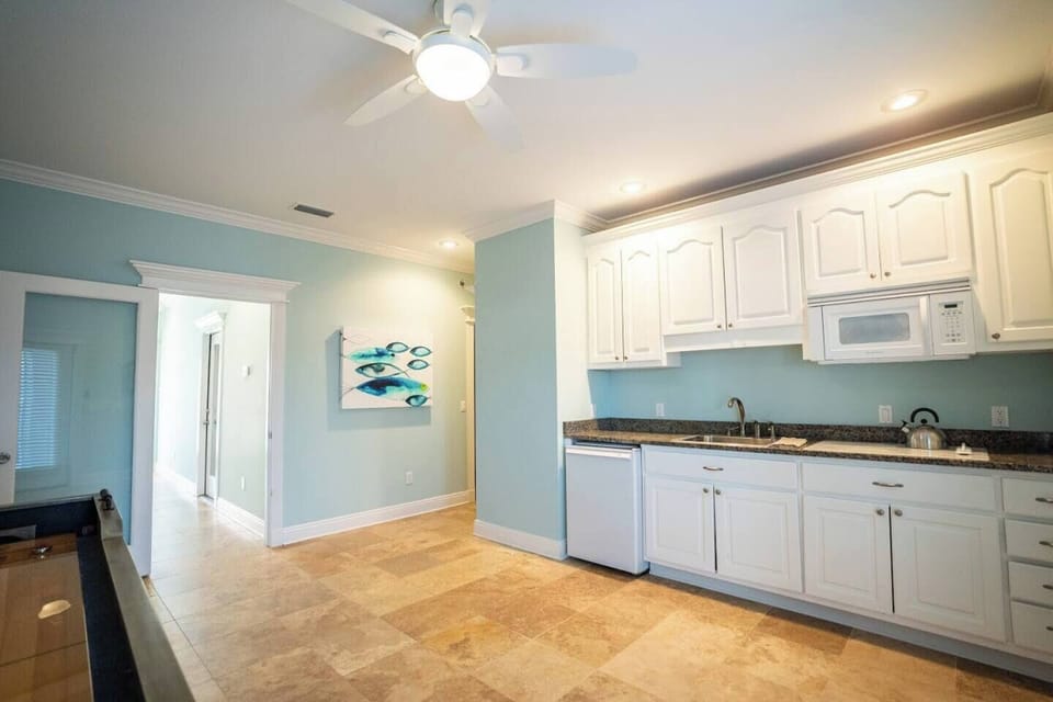 First floor sitting room, kitchenette, shuffle board, electronic dart board and since picture was taken we have added a cafe table with two chairs.  Hallway to the left leads to the front door and stairs to the second floor.  