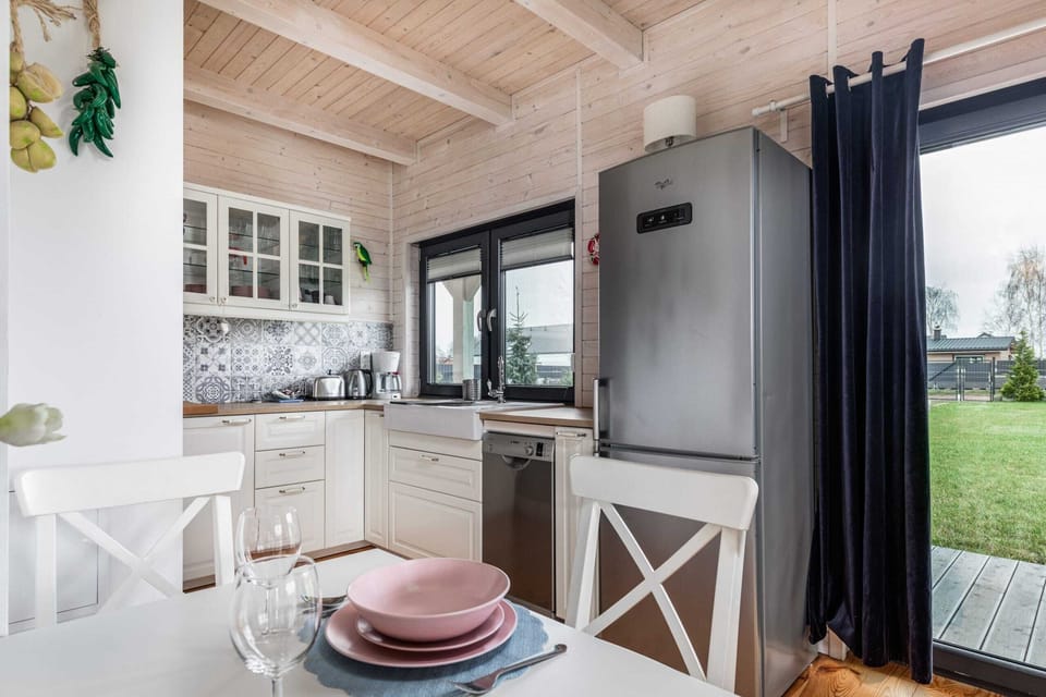 A view of the white dining room with the kitchenette in the background.