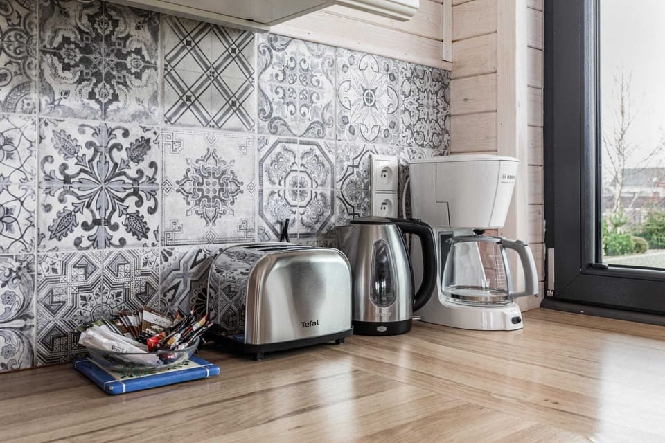 Kitchen corner with a wicker tray of coffee essentials, an electric kettle, and a clean countertop. Ideal for a quick breakfast or tea break.