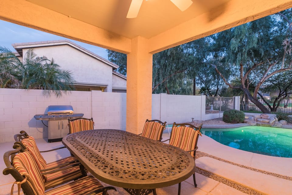 Covered patio with outdoor BBQ and dining table.
