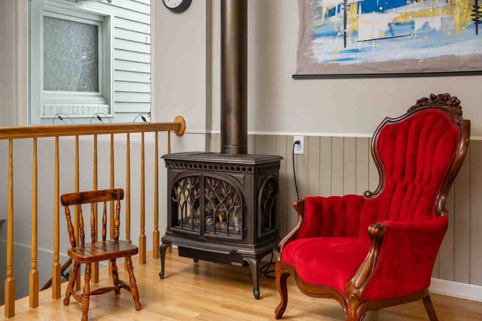 Enjoy sitting in this comfy chair next to a warm decorative stove.