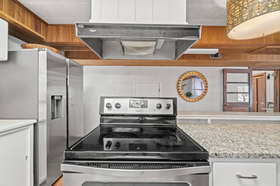 Stove set into center island of large spacious kitchen.