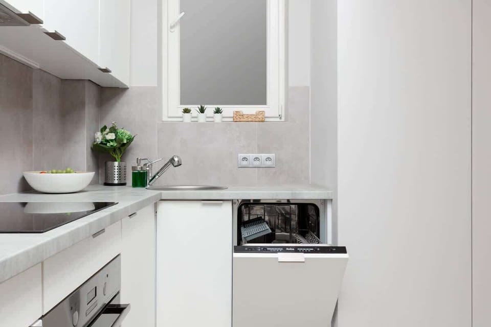 Modern kitchen featuring white cabinetry, gray tile backsplash, and open shelving for a functional and aesthetic appeal.