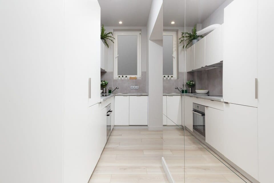 Bright hallway with large wardrobe with mirrored doors. The hallway leads to the kitchen area.