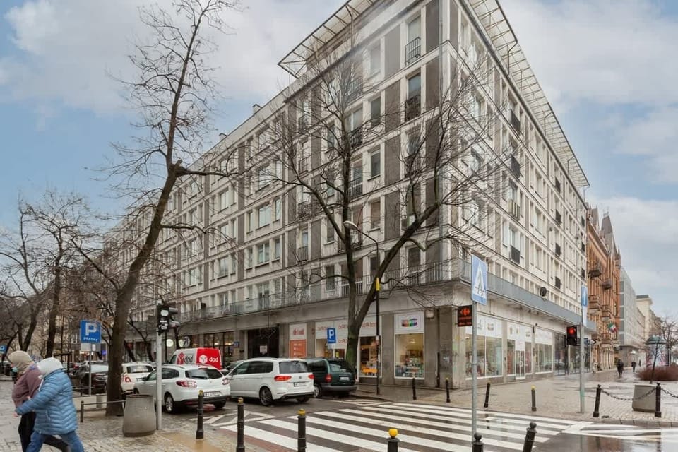 A snapshot of a sunny urban neighborhood, featuring vibrant residential buildings and tree-lined streets.