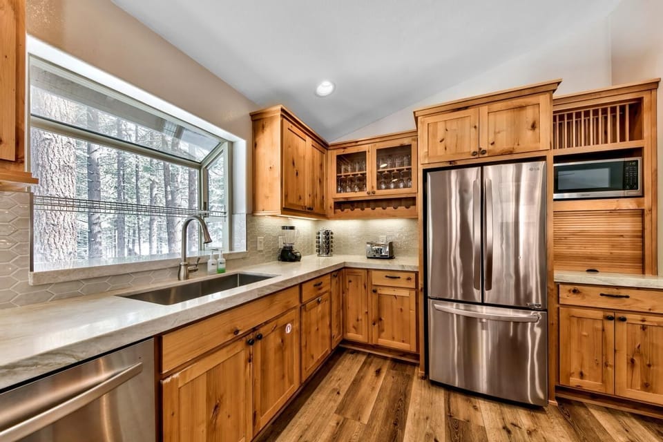 Your gourmet kitchen features warm wood cabinetry, stainless appliances, and stunning forest views that make cooking a joy.