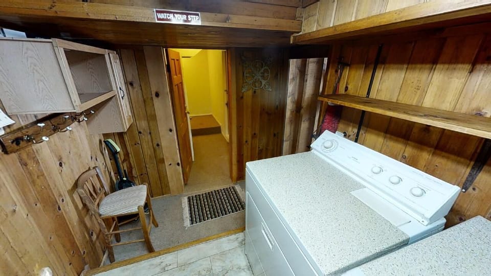 Step down into your private laundry area, complete with washer, dryer, and open shelving for all your storage needs—a rare convenience that makes longer stays effortless.