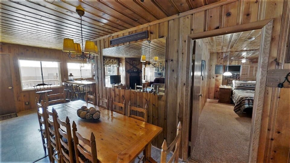 Warm wood paneling and cozy rustic charm greet you in this inviting space. A welcoming dining area flows naturally into comfortable bedrooms, perfect for gathering and relaxing during your mountain getaway.