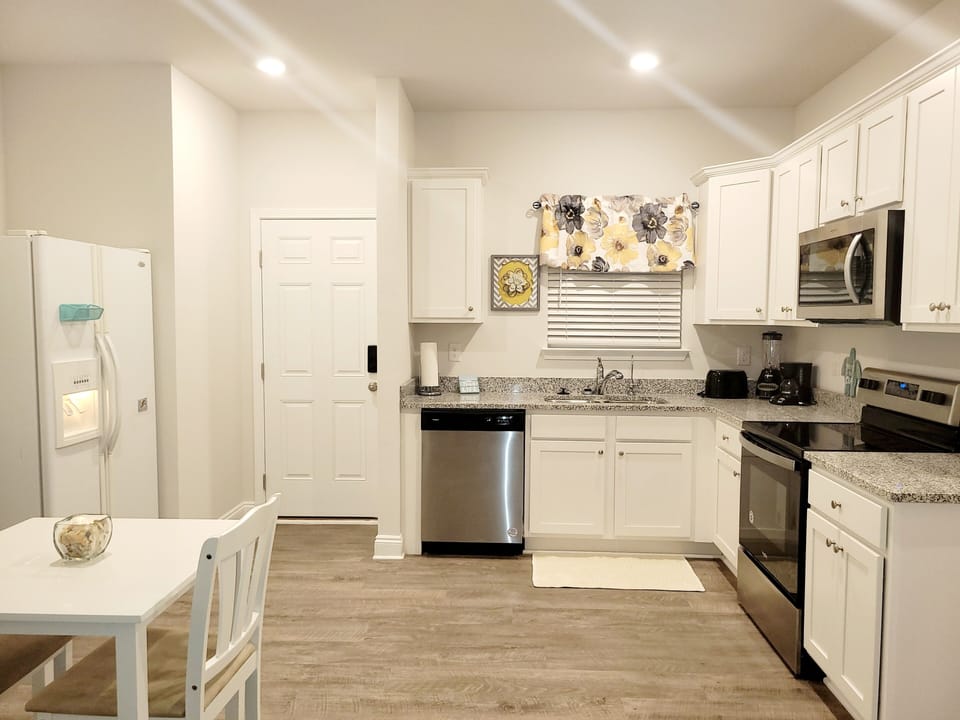 full kitchen. stovetop, refrigerator, oven, offee maker, microwave, dining table