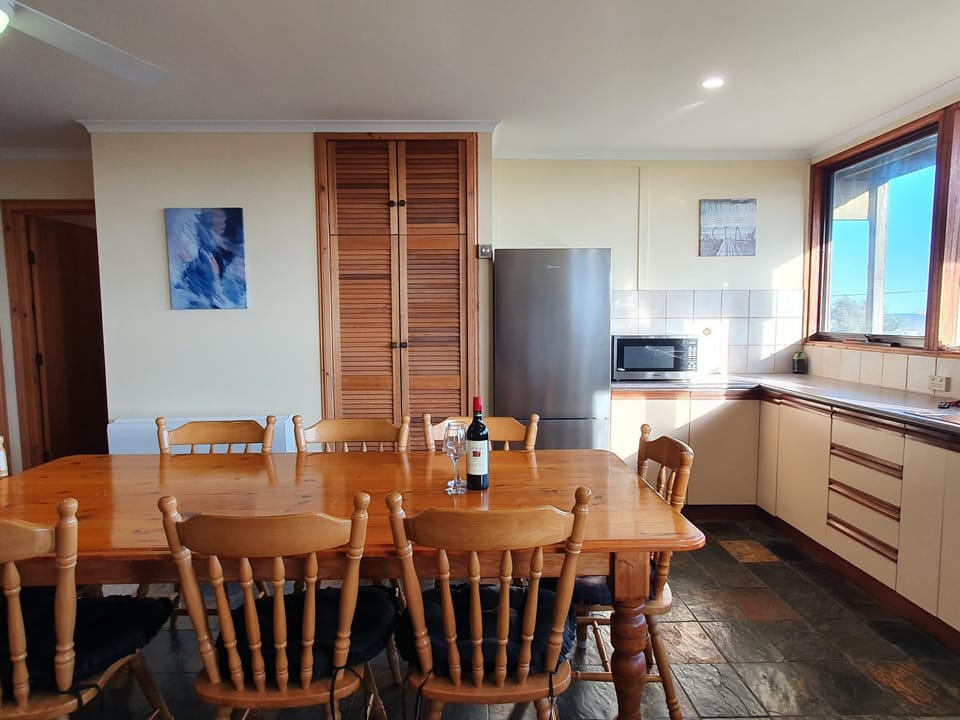Lower level with bedrooms and dining; upper-level second lounge with a 7-seater couch and deck access—ideal for families or groups.