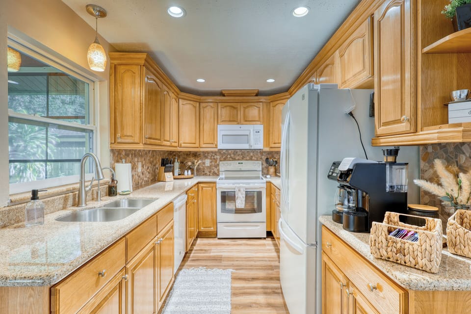 Modern kitchen with full appliances, cookware, and sleek countertops.