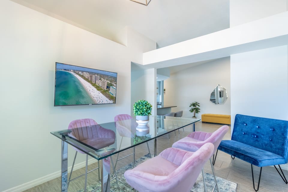 Elegant dining room/ sitting room with modern furniture, art and 50” smart TV.