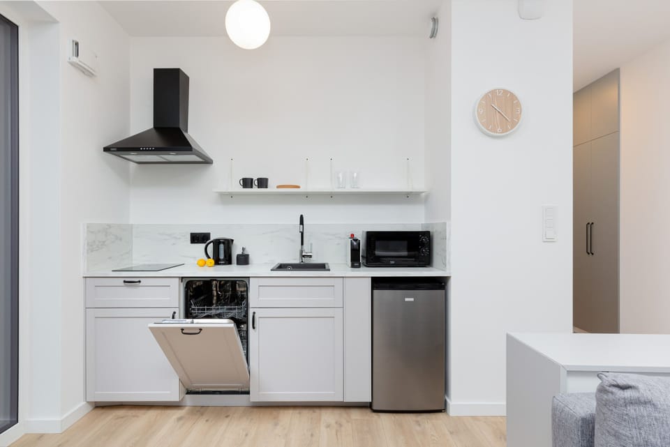 Modern kitchen with white cabinets and white appliances. The whole creates a practical space for preparing home-cooked meals.