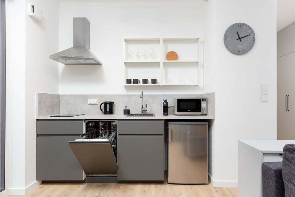 Modern kitchen with gray cabinets and white appliances. The whole creates a practical space for preparing home-cooked meals.