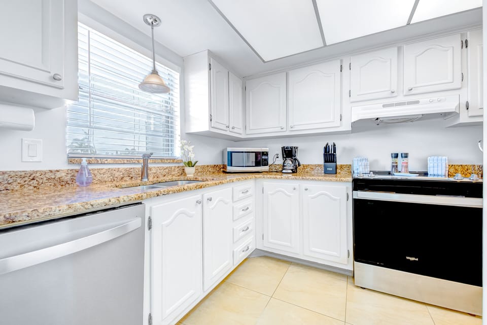 Sleek and modern kitchen with white cabinetry and plenty of natural light
