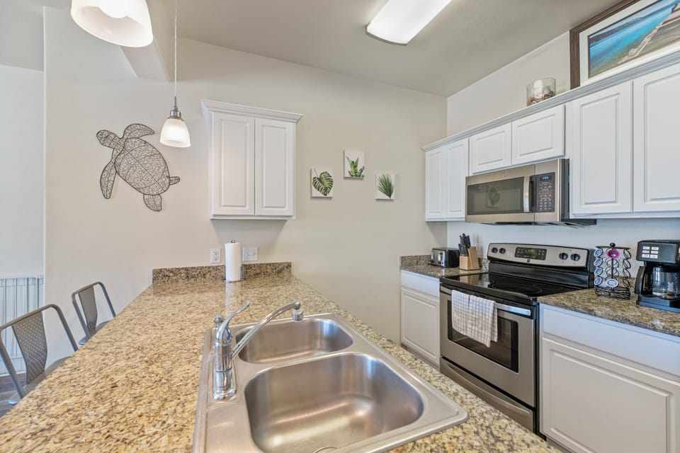 Gather around this bright kitchen where white cabinets and granite counters invite you to cook memorable meals together.
