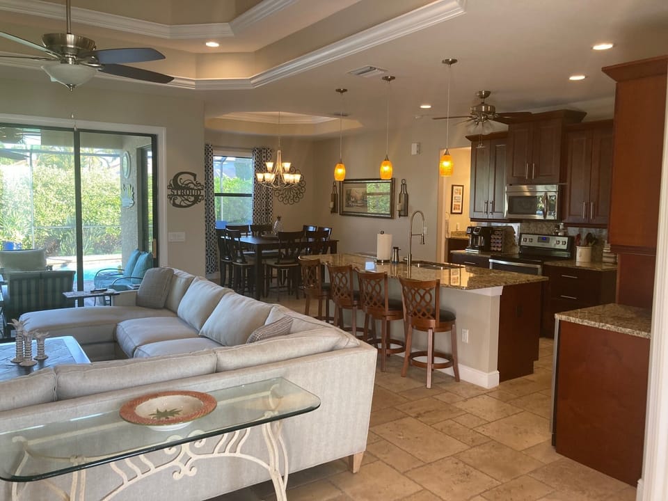 Living and dining area, patio doors open completely to pool area