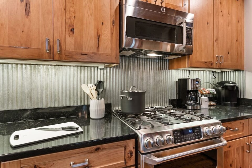 Kitchen features a gas stove, dishwasher & stainless steel appliances.