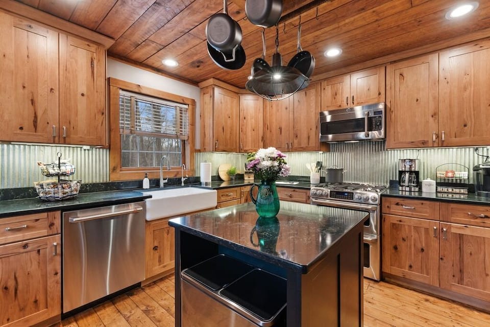 Fully equipped kitchen w/ hanging pots, rustic cabinetry, and room to cook together.