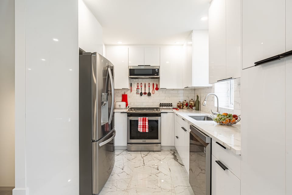 Step into this modern kitchen featuring a gas oven, fridge with ice-making, etc.