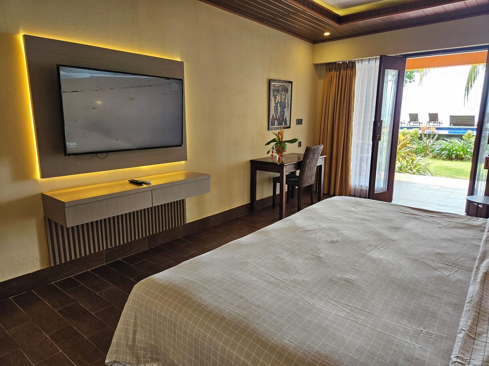 Deluxe Room, Sea View, Beachside | Minibar, in-room safe, desk, blackout drapes