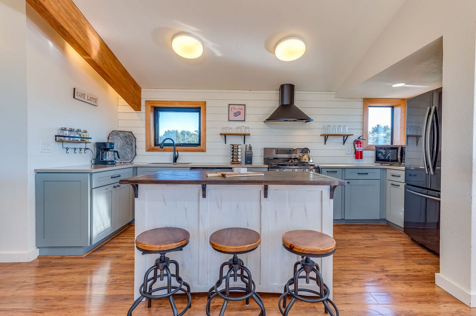 Fully equipped kitchen with island with 3 seats and adjacent breakfast nook.