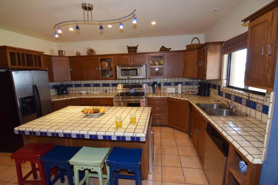 The kitchen at Casa Welch is fully equipped for gourmet meal prep — featuring modern appliances, a professional cooktop and ovens, and even a cappuccino machine for morning coffee .