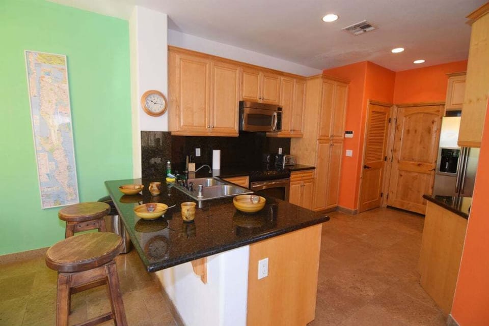 The fully equipped kitchen at Condo 234 includes a refrigerator, stove, microwave, coffee maker, and essential cookware
