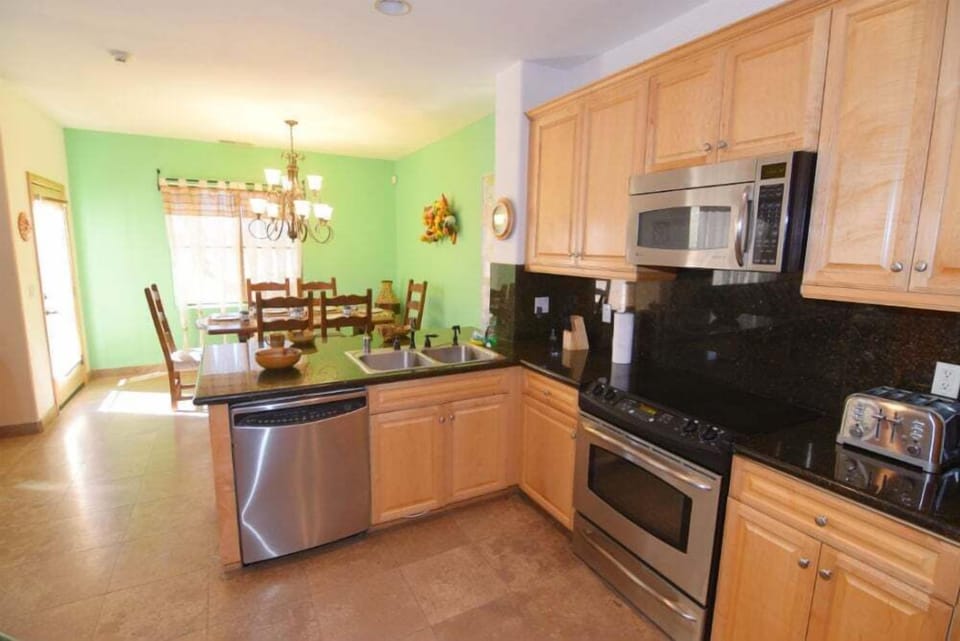 The fully equipped kitchen at Condo 234 includes a refrigerator, stove, microwave, coffee maker, and essential cookware