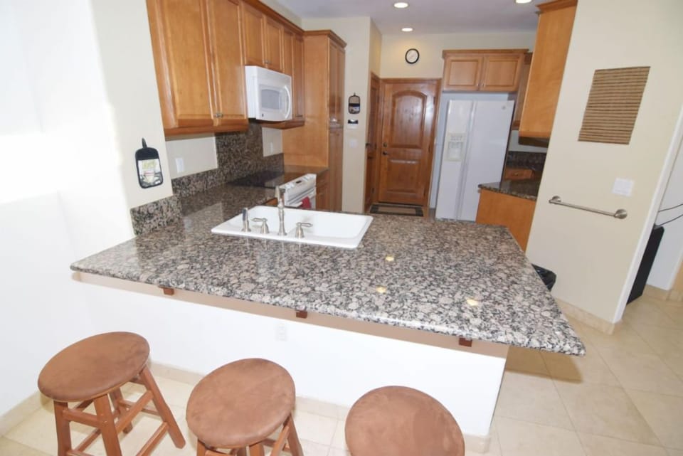 This full kitchen features stainless steel appliances, granite countertops, an oversized island with prep space, and a walk-in pantry.