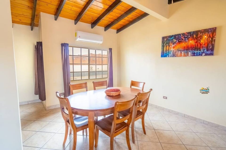 This view of the dining table highlights its open connection to the living room and kitchen — a central spot for group meals just steps from the beach.