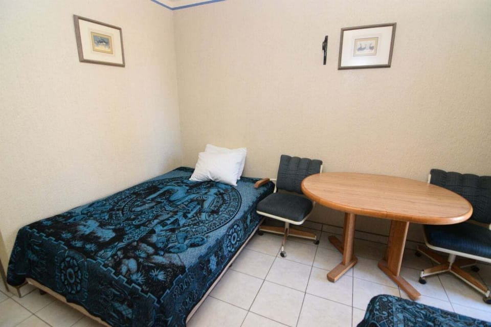 The bedroom includes a second bed in a space designed for group stays. Offers A/C and separate sleeping areas in one studio layout.