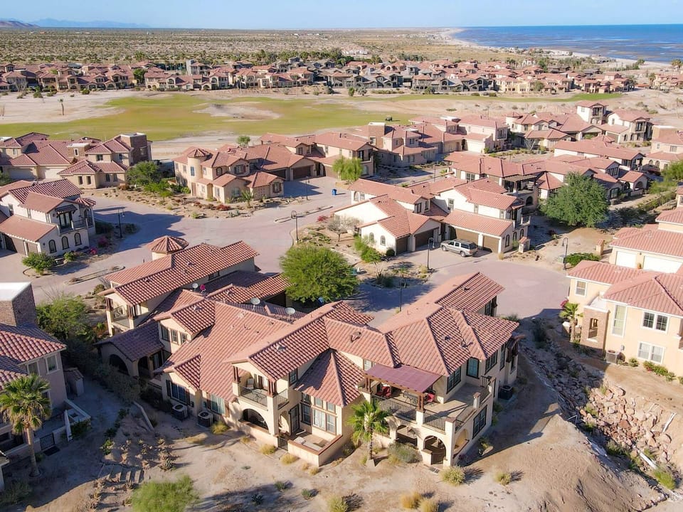 This aerial view shows Condo 322's prime location with panoramic sightlines across the Las Caras de Mexico golf course all the way to the Sea of Cortez beach .
