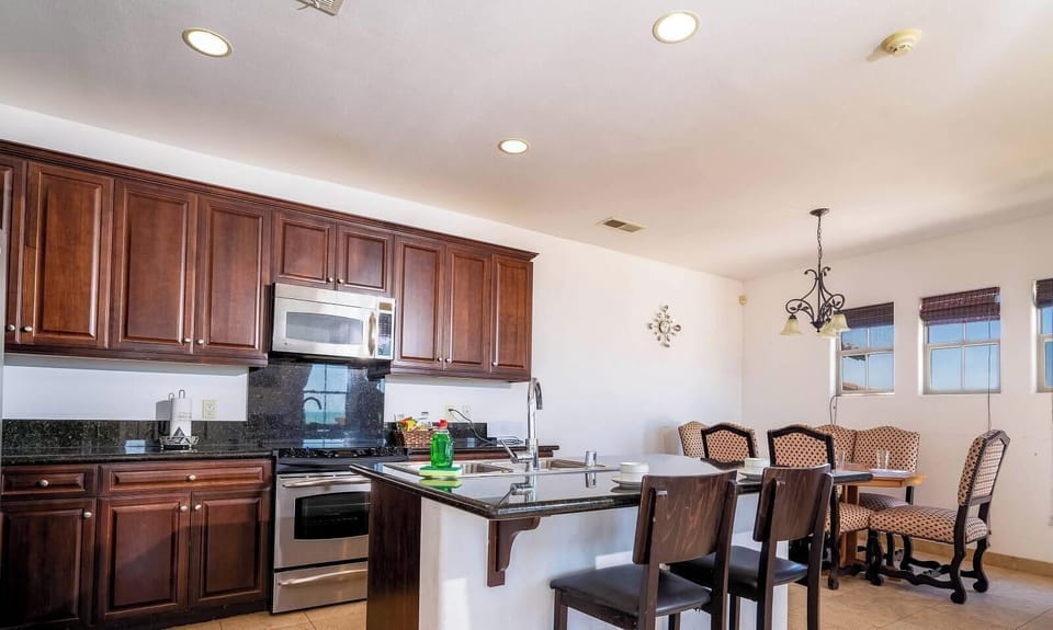 Open kitchen with breakfast bar and adjacent dining table — perfect for group meals .