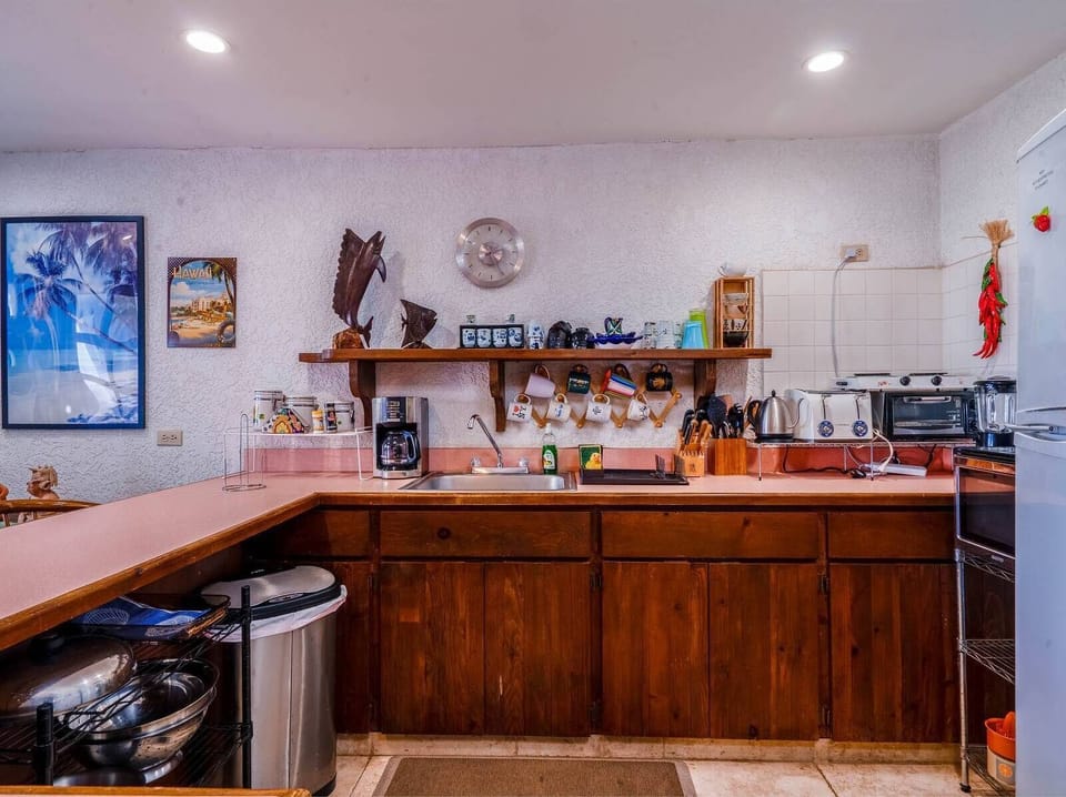 A functional and modern kitchen space featuring sleek cabinetry and updated appliances, perfectly situated for convenient meal preparation during your vacation stay.