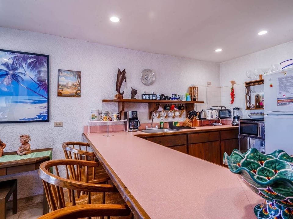 A fully equipped kitchen showcasing a clean, modern layout with plenty of cabinet space and essential appliances, making it an ideal setup for families and long-term guests.