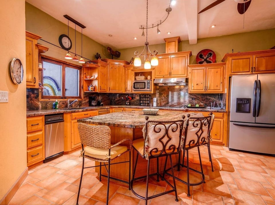 The kitchen island features granite countertops and bar stool seating, perfect for casual meals or morning coffee.
