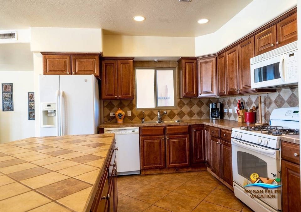 Open floor plan with kitchen island and bar stools. Fully equipped with microwave, oven, refrigerator, blender, coffee maker, and cooking range