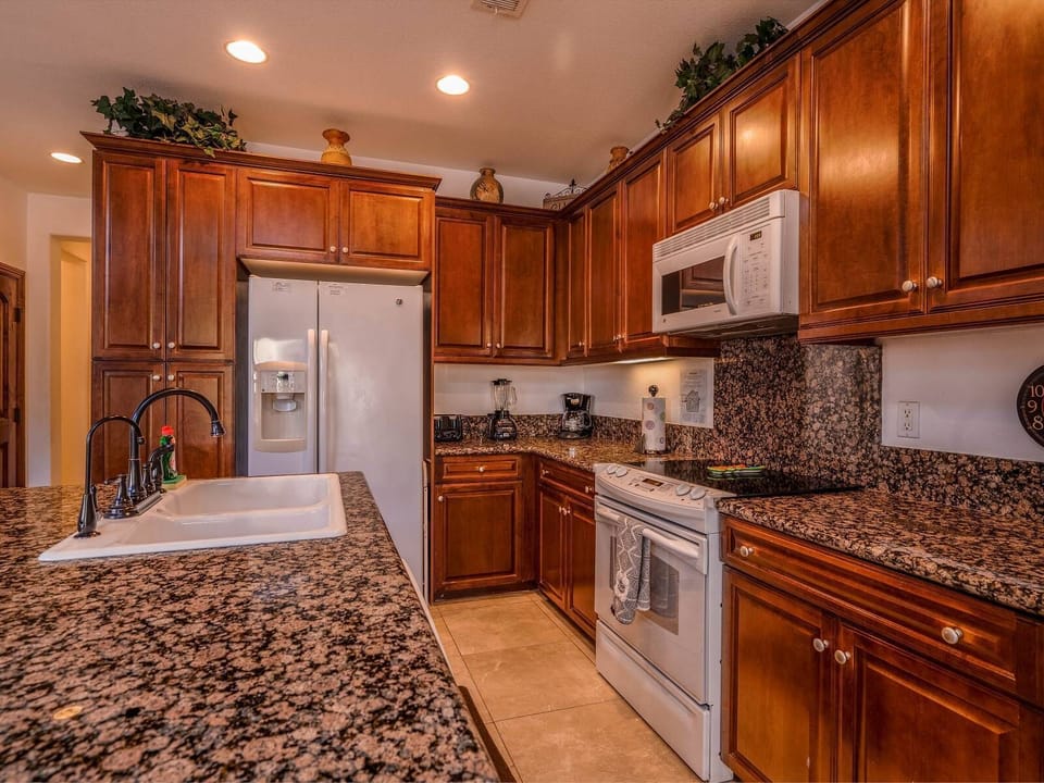 The kitchen at Condo 92 includes a refrigerator, microwave, coffee maker, and kitchenware — all on the ground level for easy meal prep before heading to the nearby heated swimming pool .
