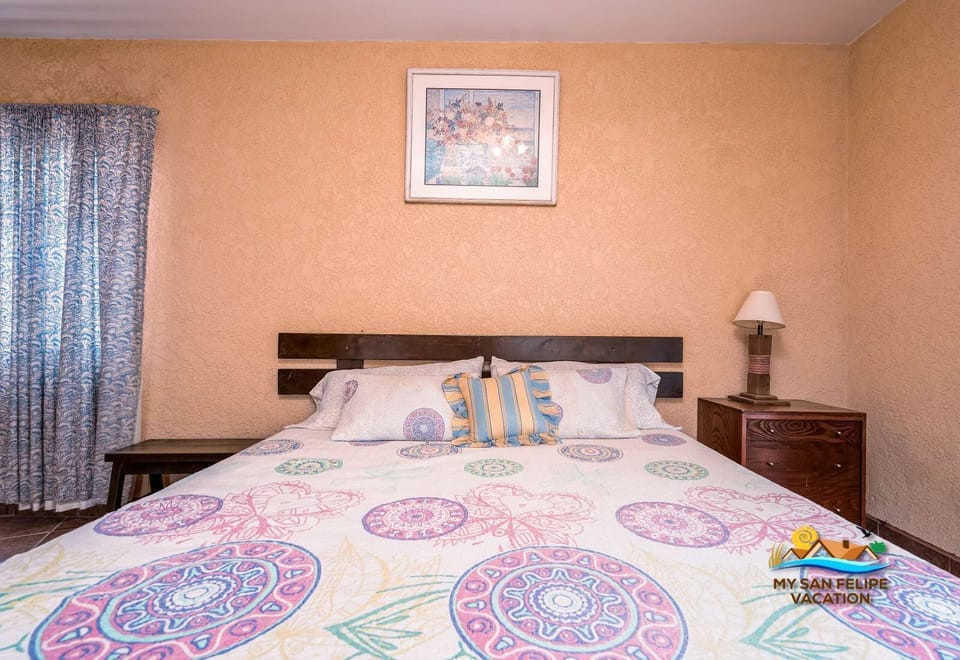 The primary bedroom offers a serene retreat with a comfortable bed, stylish linens, and a bright, airy atmosphere designed for a restful night's sleep.