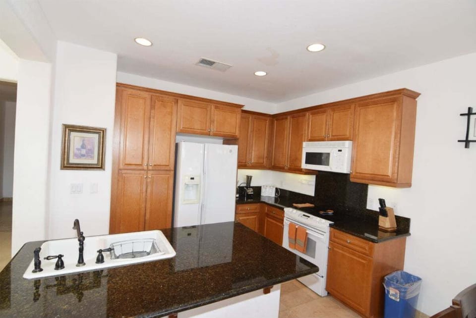 The dining area at Condo 25-1 features a table with seating, located conveniently off the fully equipped kitchen and living room in this open-concept vacation rental .