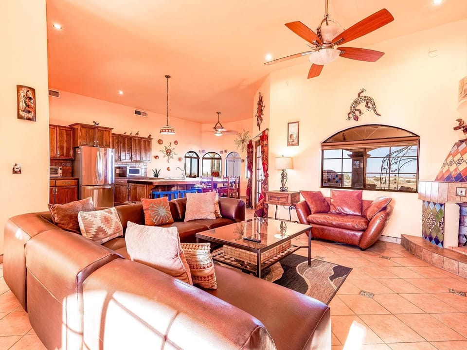 The living room at Casa Zur Heide features a beautifully tiled fireplace, modular seating for entertaining, flat-screen TV with American Dish, and French doors that open to the backyard patio