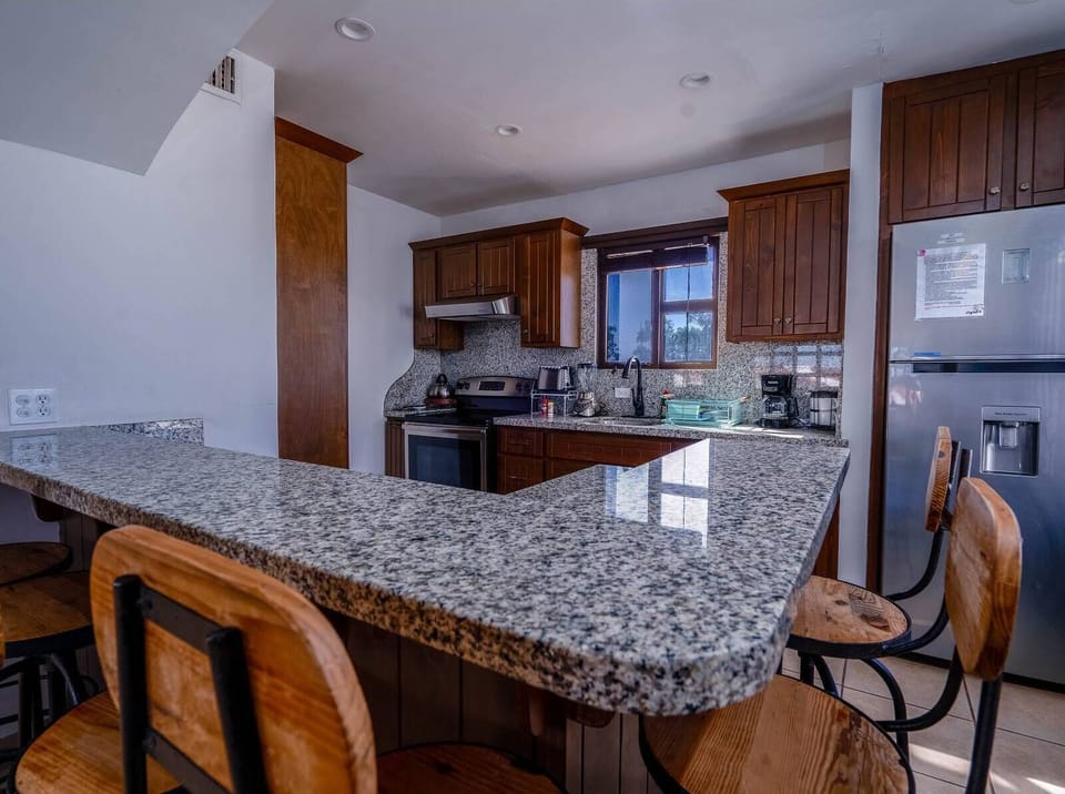 A sleek and spacious kitchen counter offering plenty of prep space for home-cooked meals or serving up snacks for the group.