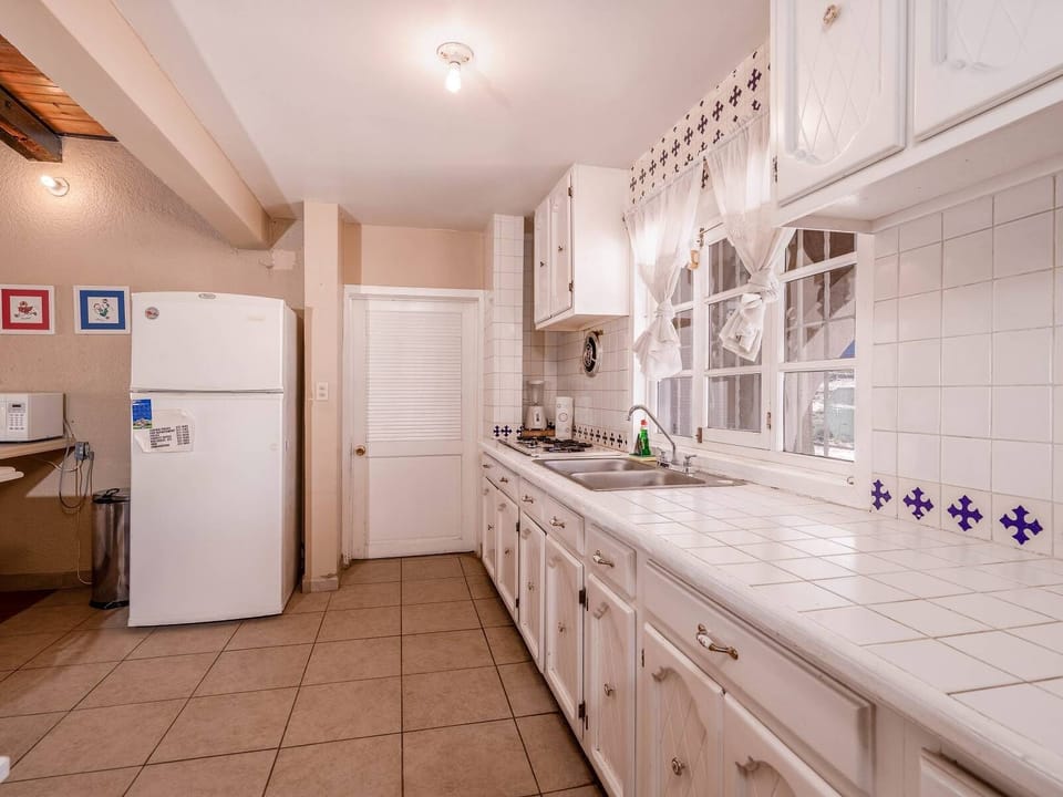 Full-size refrigerator and stove included in this well-appointed kitchen for home cooking.