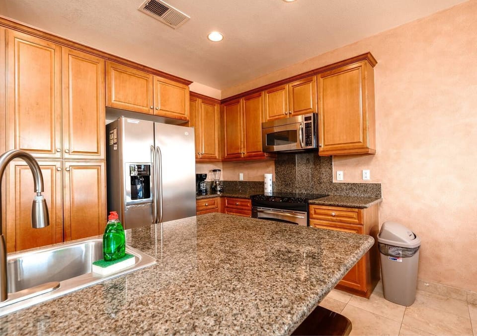The recently updated kitchen features granite countertops, custom cabinets, stainless steel appliances, a center island with bistro seating, and every gadget needed to cook meals just like at home