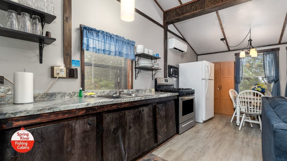 Full kitchen with drip coffee maker, toaster, crock pot, dishes, pans, gas stove, and full-sized fridge. 